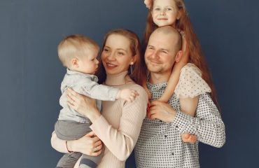 A joyful family portrait showcasing parents and their two children, expressing love and togetherness.